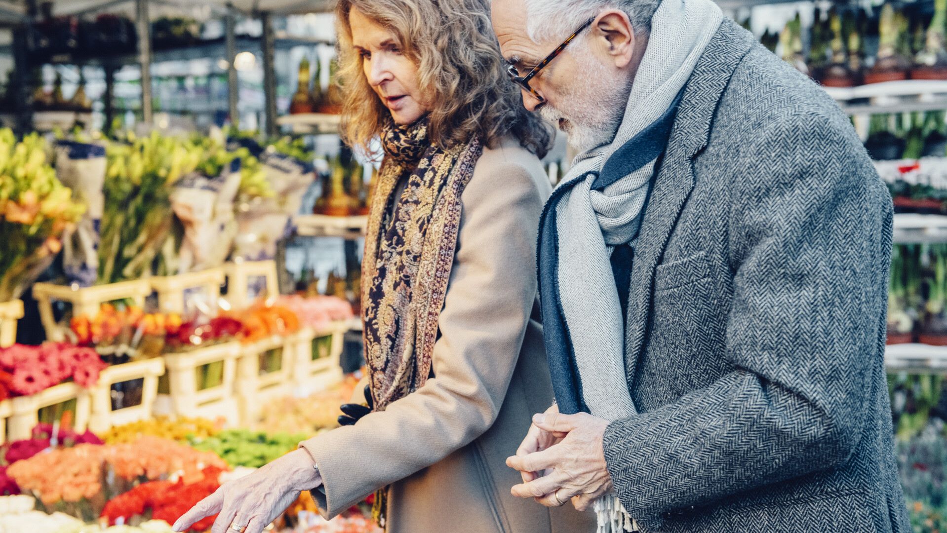 Seniorer köper blommor på marknad