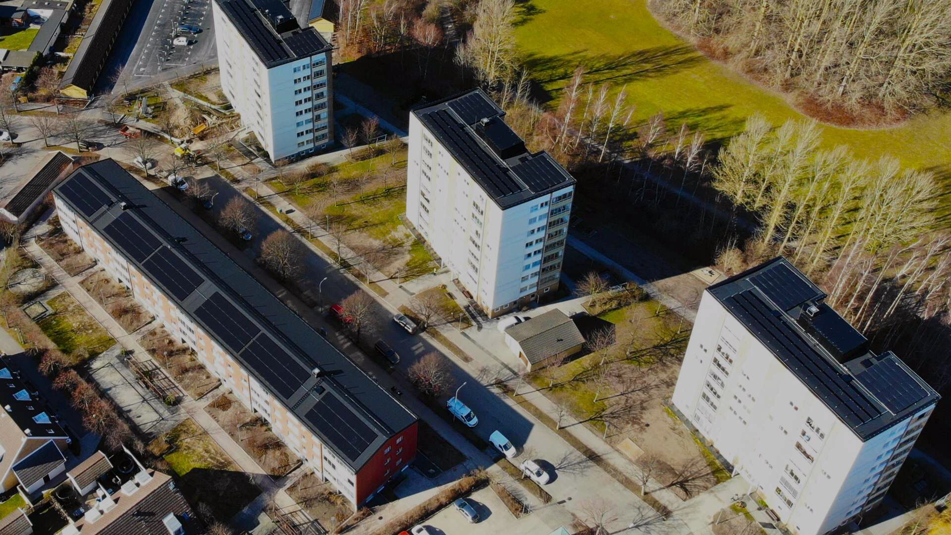 Flygbild av bostadshus brf Trelleborgshus med solpaneler på taken och omgivande grönområden