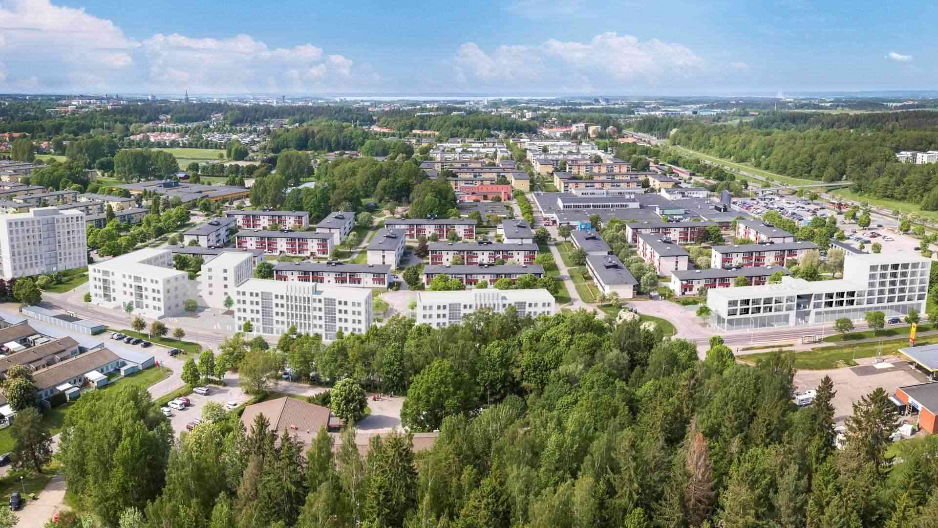 Flygbild av en förort med moderna bostadshus omgivna av grönområden och träd
