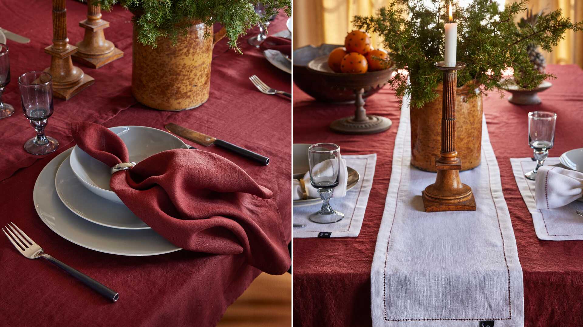 Dukat bord med röd bordsduk, grå tallrikar, röda linneservetter, bestick, glas och dekorativa ljusstakar samt grön växt och apelsiner i skål