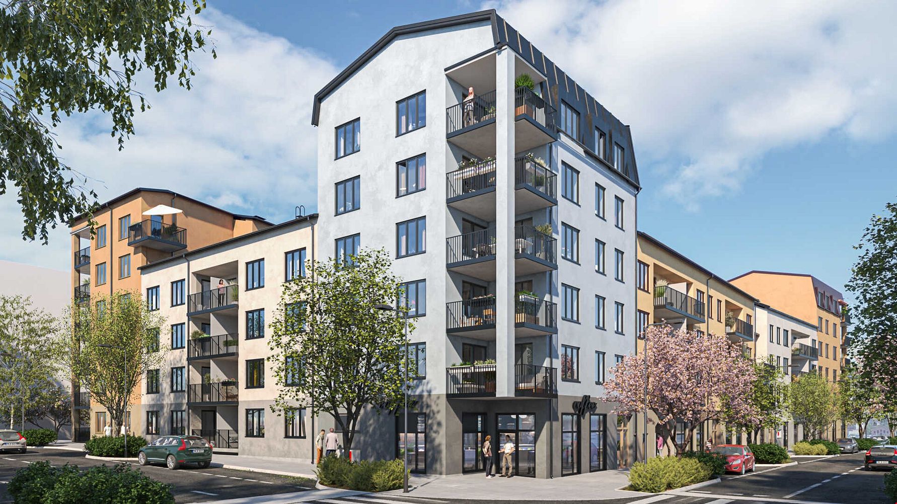 Flerfamiljshus med moderna fasader, balkonger och träd vid en gata med parkerade bilar under en klar himmel