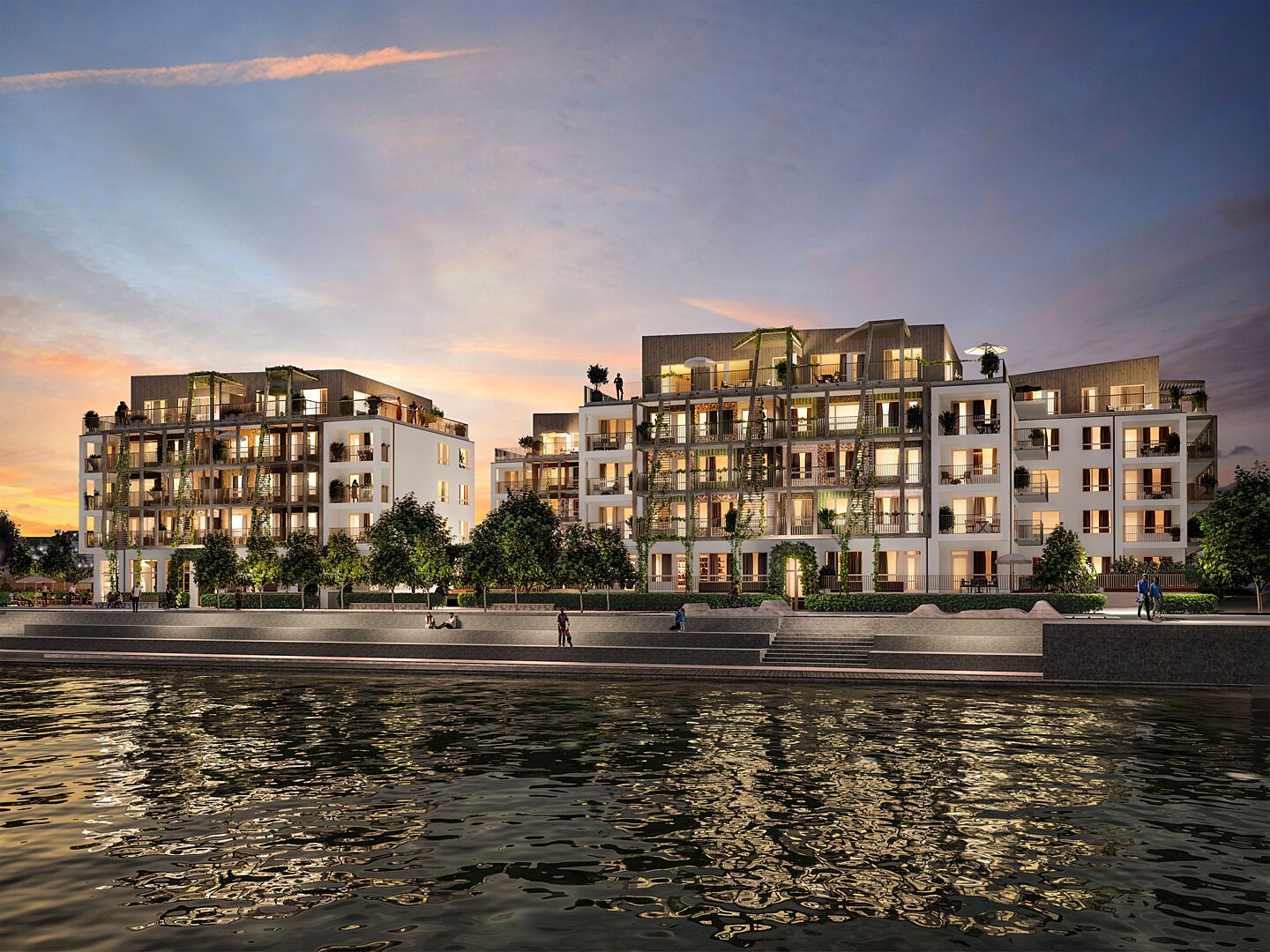 Nybyggda flerfamiljshus vid vattnet i solnedgång, med träd och gångväg längs strandpromenaden