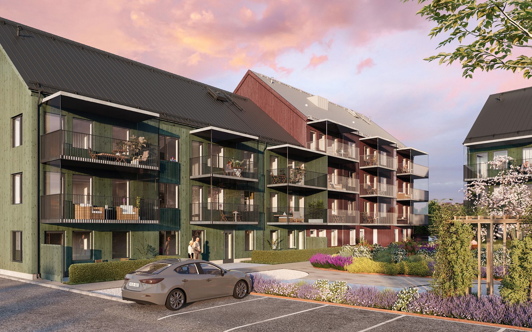 Flerfamiljshus i trä med balkonger, omgivna av grönska och färgglada växter, samt en parkeringsplats med en bil i förgrunden