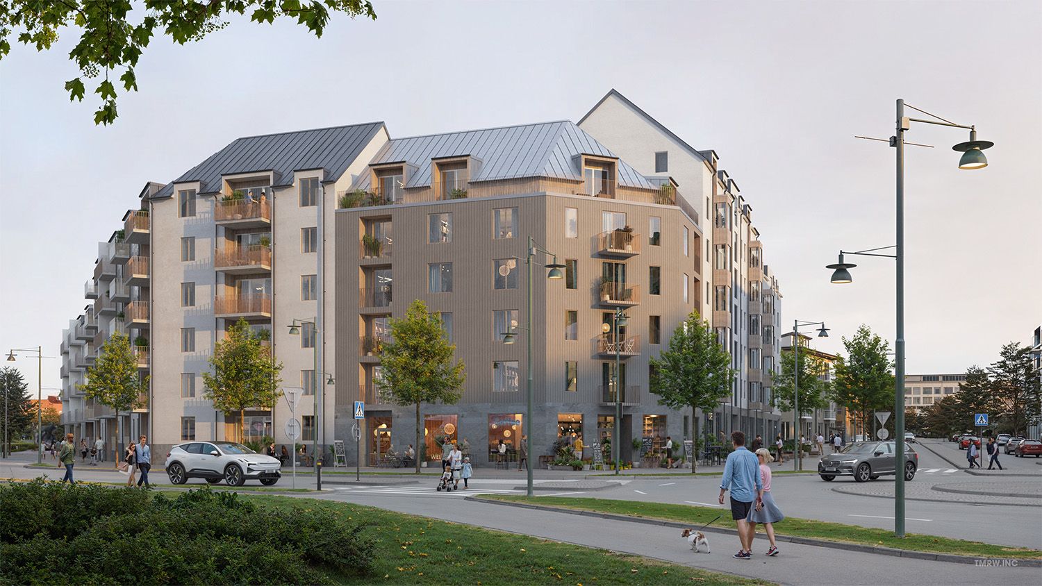 Nybyggd flerfamiljsfastighet med modern arkitektur, omgiven av gröna träd, trottoarer och gatlampor. Människor promenerar och en bil är parkerad nära byggnaden