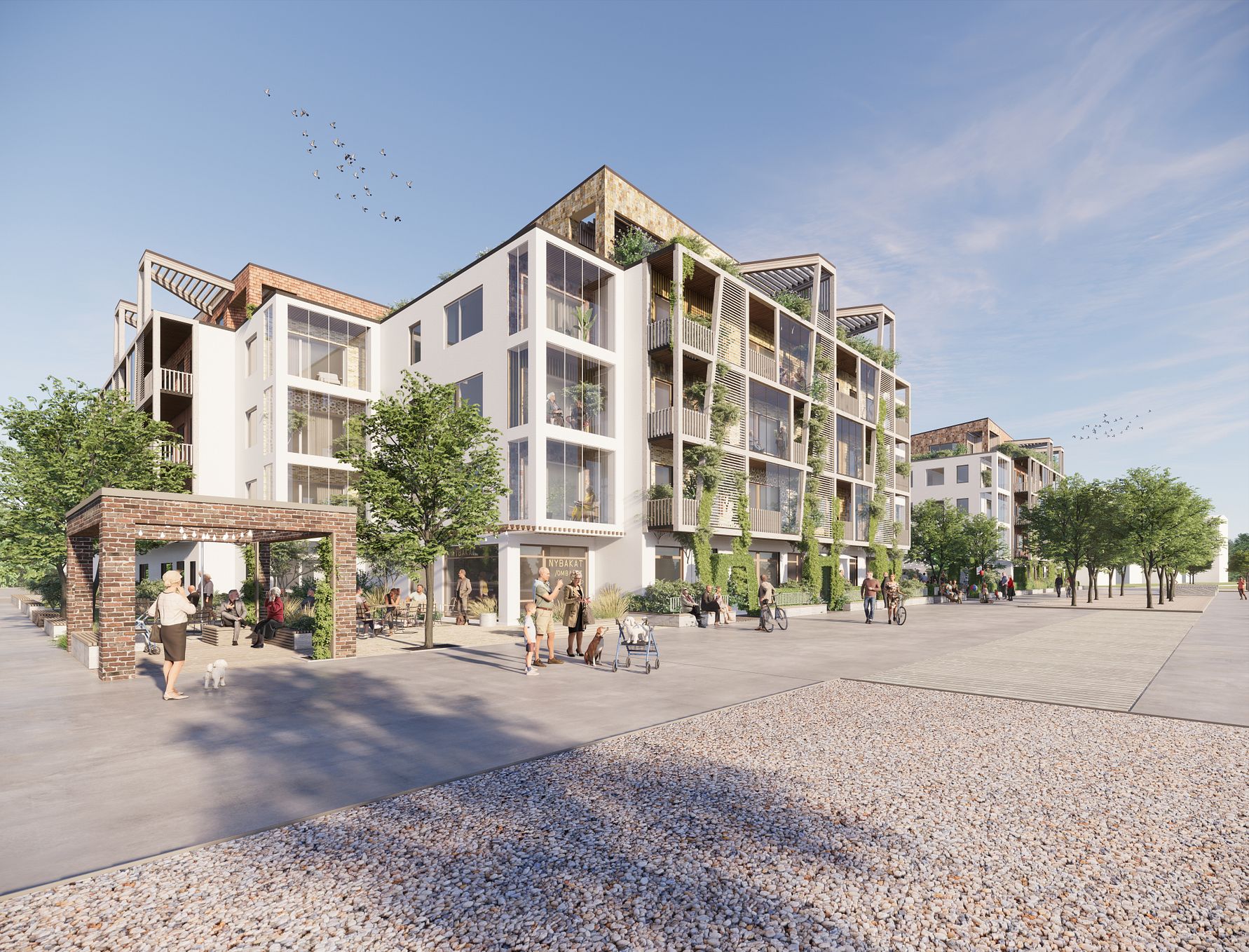 Modern flerfamiljshus med grönskande fasader och stora glaspartier, omgiven av träd och en öppen stenlagd plats under blå himmel