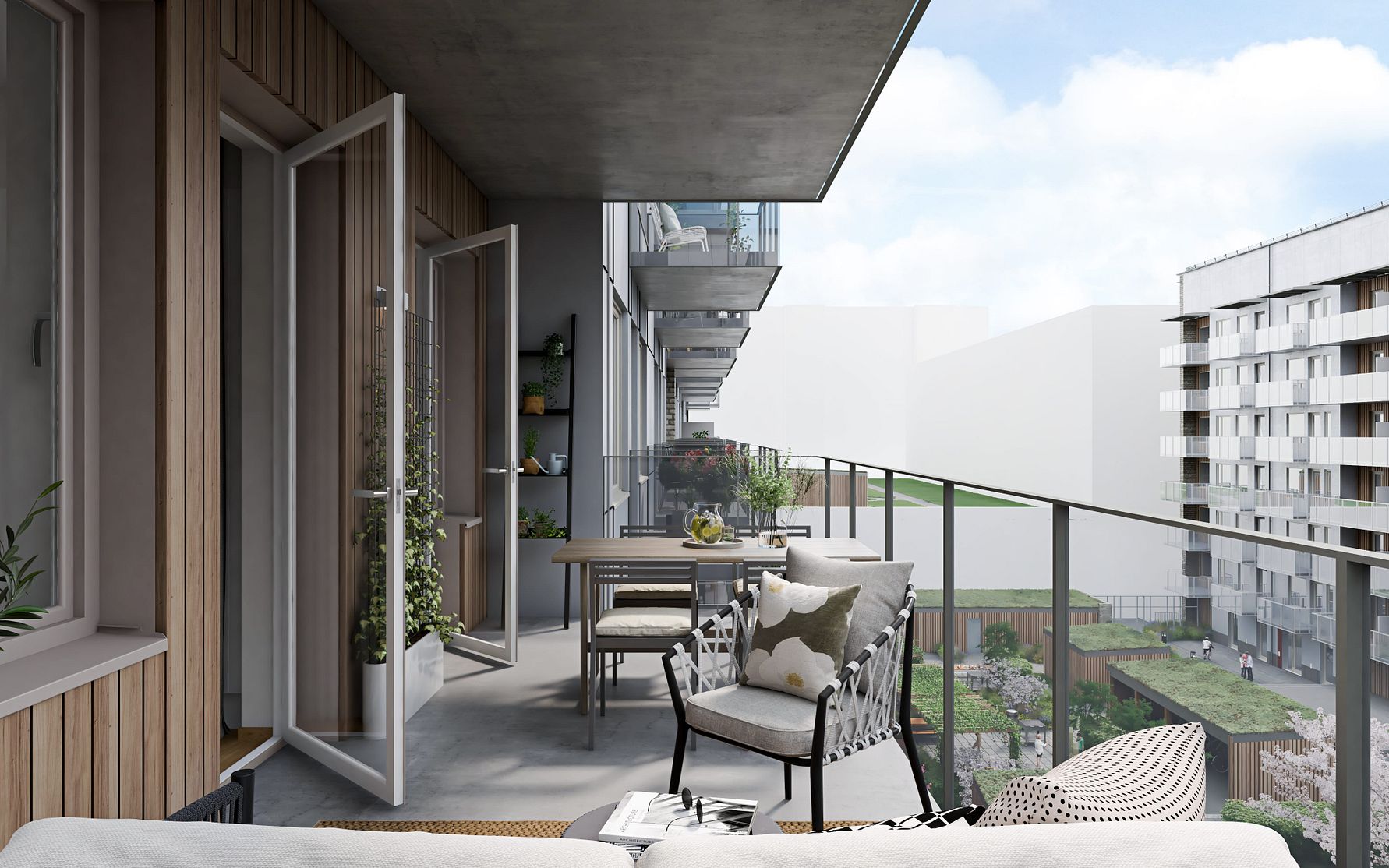 Balkong med utemöbler, växter och utsikt över en modern bostadsområde med grönområde i bakgrunden