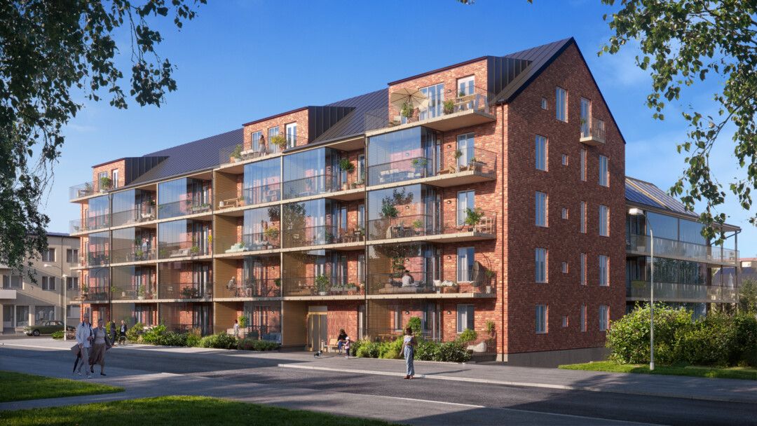 Flerfamiljshus i tegel med stora glasbalkonger, omgivna av grönska och trottoarer under en klarblå himmel