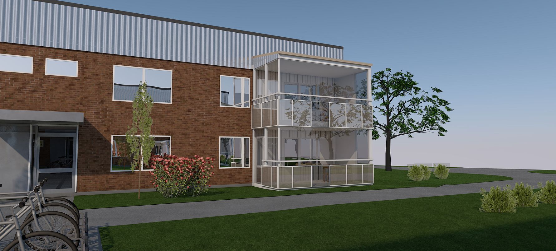En modern byggnad med tegelfasad och en inglasad balkong, omgiven av gräs, blommor och träd