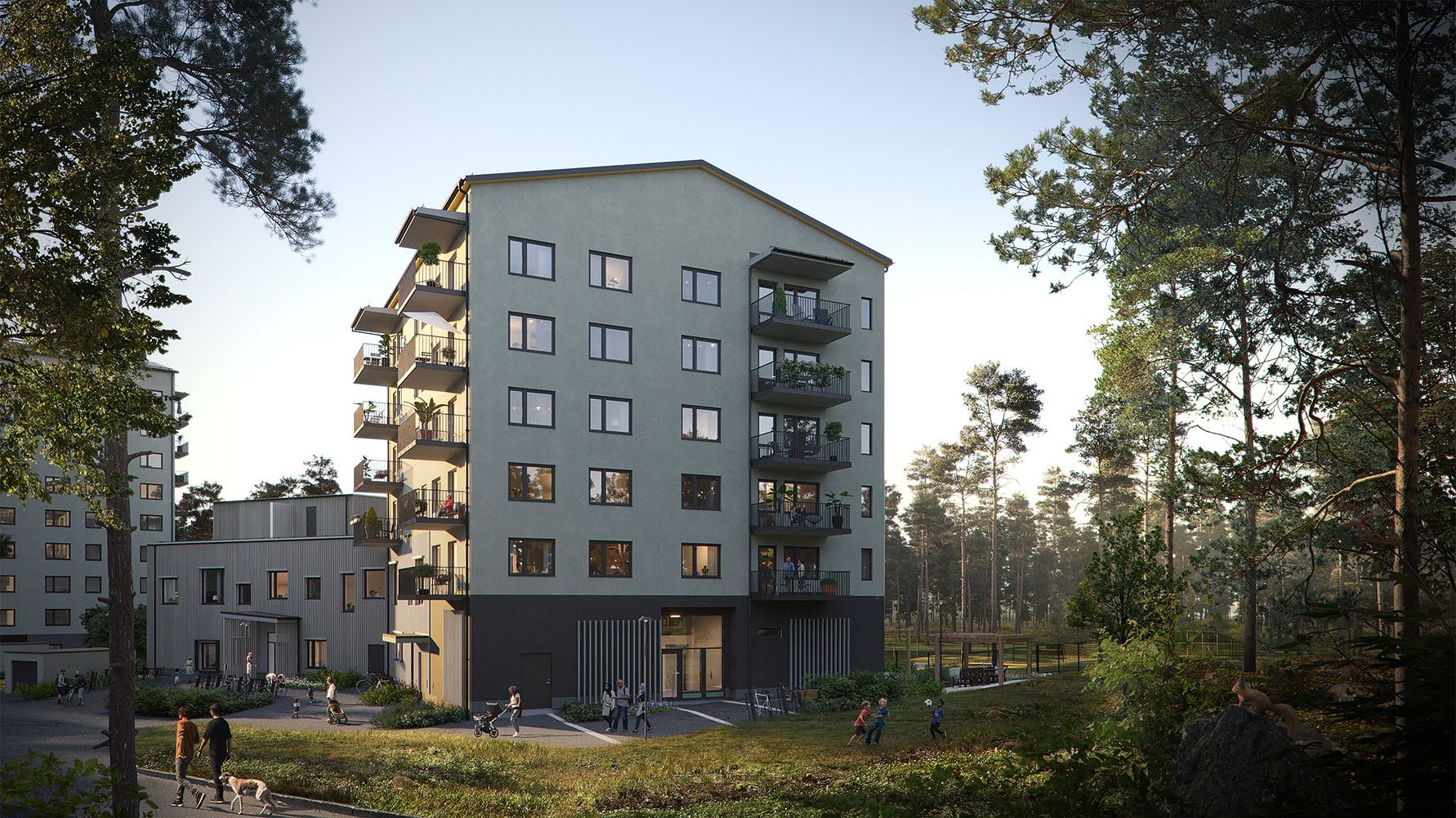 Flerbostadshus i ett naturnära område med skog i bakgrunden, människor som promenerar och hundar i förgrunden