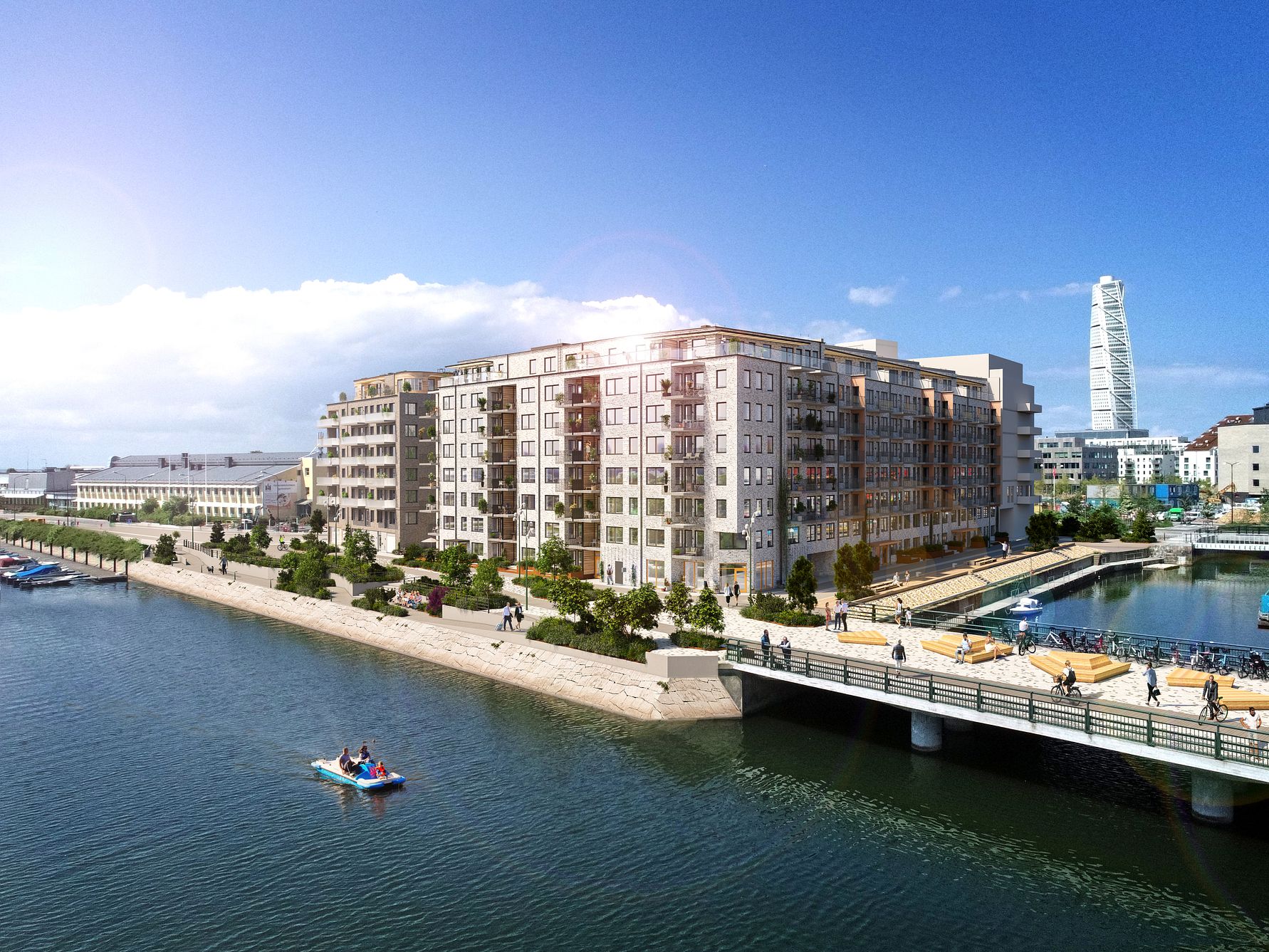 Bostadsområde med moderna flerfamiljshus vid vattnet, gångbro och en kajak på vattnet. Turning Torso synlig i bakgrunden