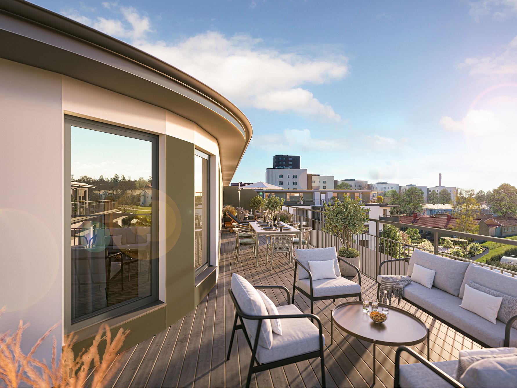 Modern balkong med utemöbler, solsken och utsikt över stadsbebyggelse och grönområden