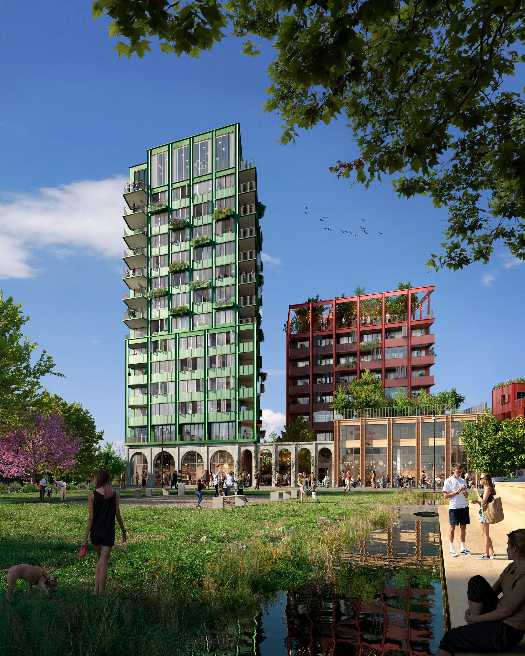 Gröna och röda flervåningshus omgivna av träd, grönområden och en liten vattendamm. Människor promenerar och vistas i parkområdet i förgrunden