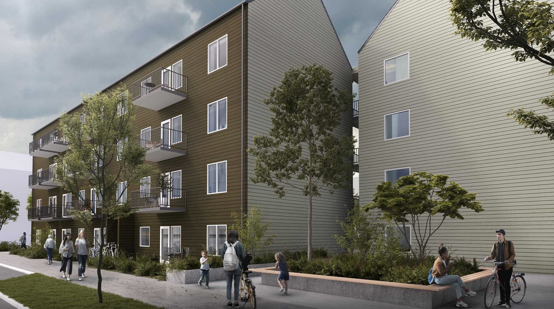 Flerfamiljshus med modern fasad, stora fönster och balkonger, omgivna av träd och gångväg där människor promenerar och cyklar