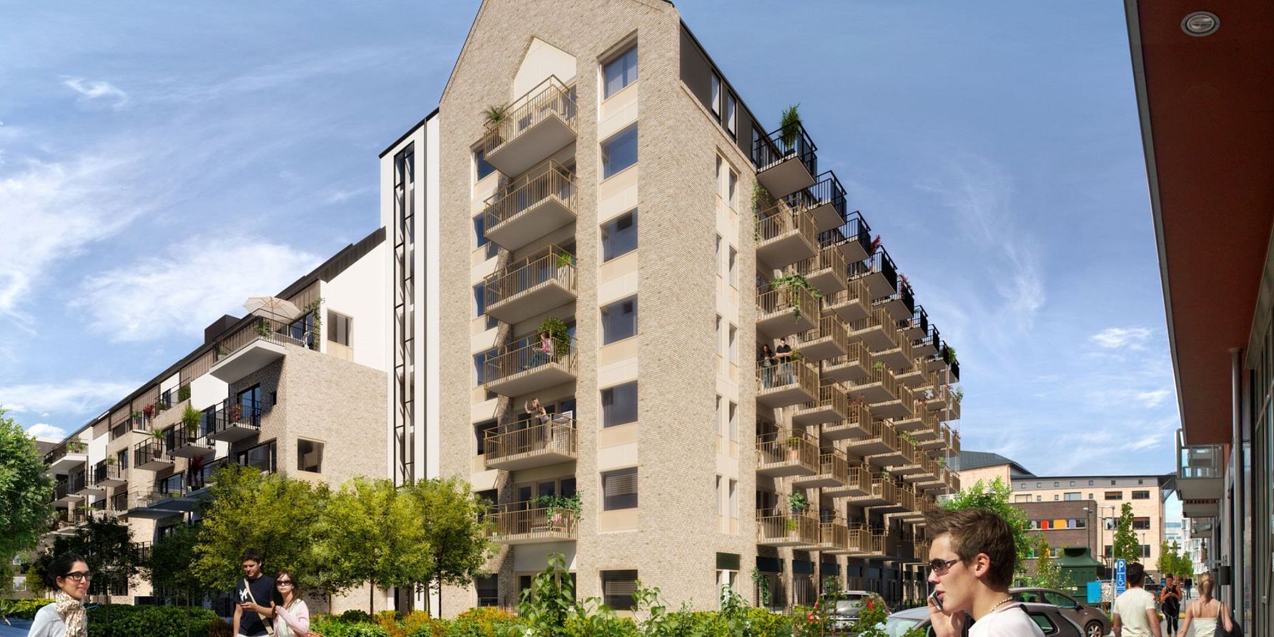 Ett modernt flerfamiljshus i ljust tegel med balkonger och gröna växter, omgiven av träd och människor som promenerar under en klarblå himmel