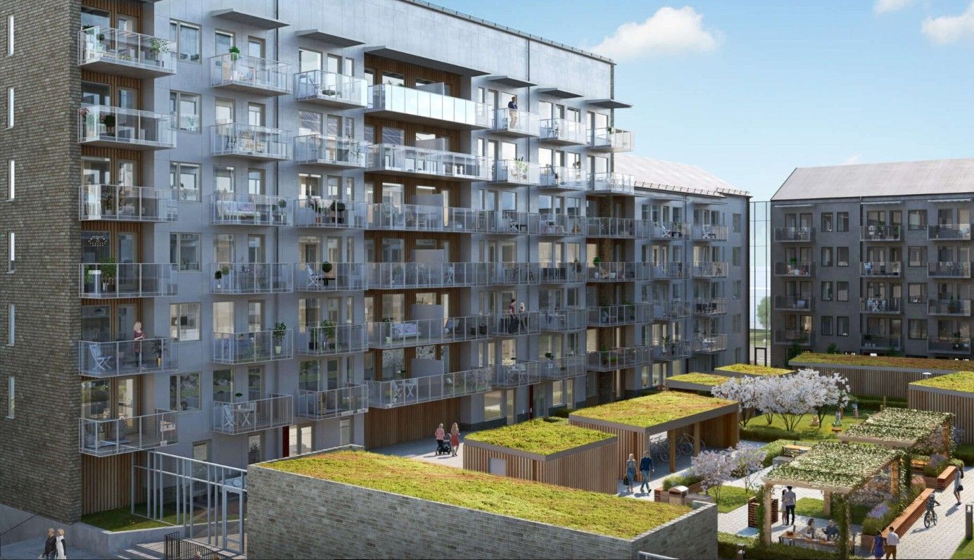 Flerbostadshus med balkonger och en innergård med grönskande tak, pergola och träd i soligt väder