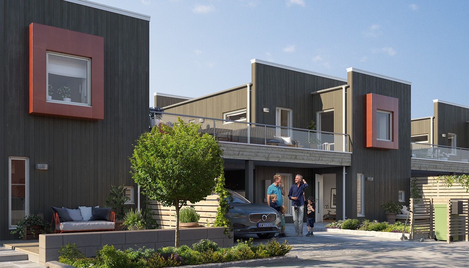 Rad av moderna radhus med träfasad, stora fönster och orangea detaljer, omgivna av grönska och parkeringsyta med en bil och människor