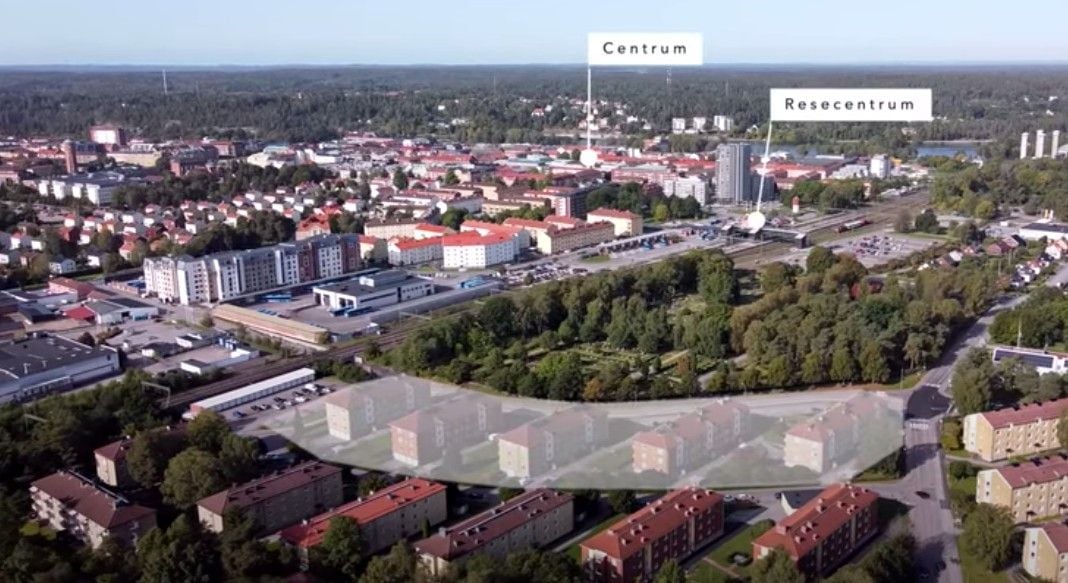 Flygvy över en stad med byggnader, grönområden och markerade platser som centrum och resecentrum