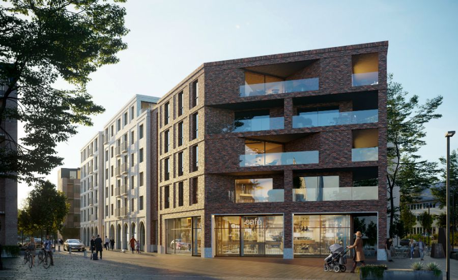 Nybyggda flerfamiljshus med modern arkitektur, fasader i tegel och stora glaspartier, omgivna av träd och en stadsnära miljö