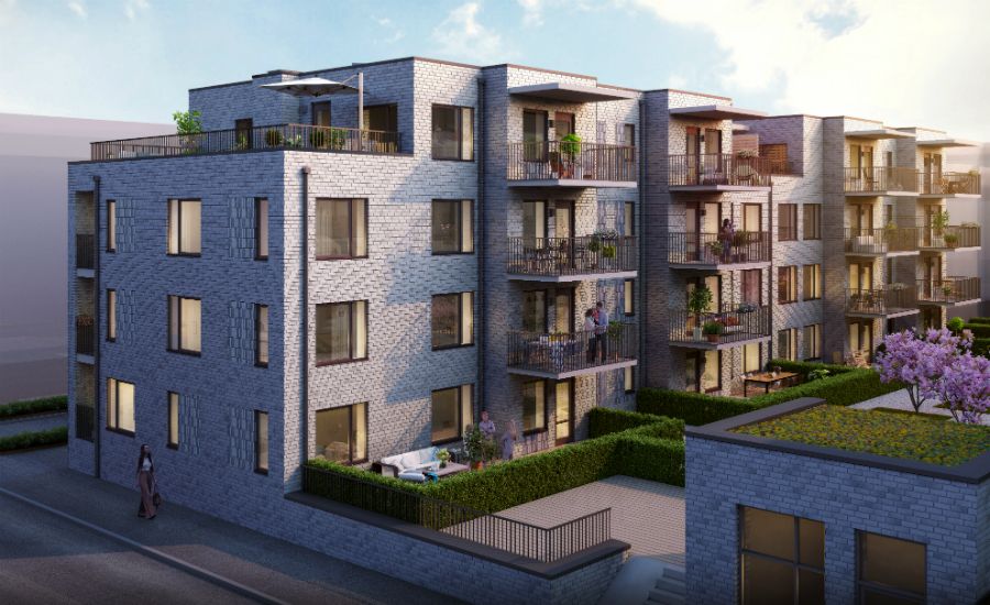 Flerfamiljshus med modern arkitektur, flera balkonger och grönområden runt byggnaden under en klar himmel