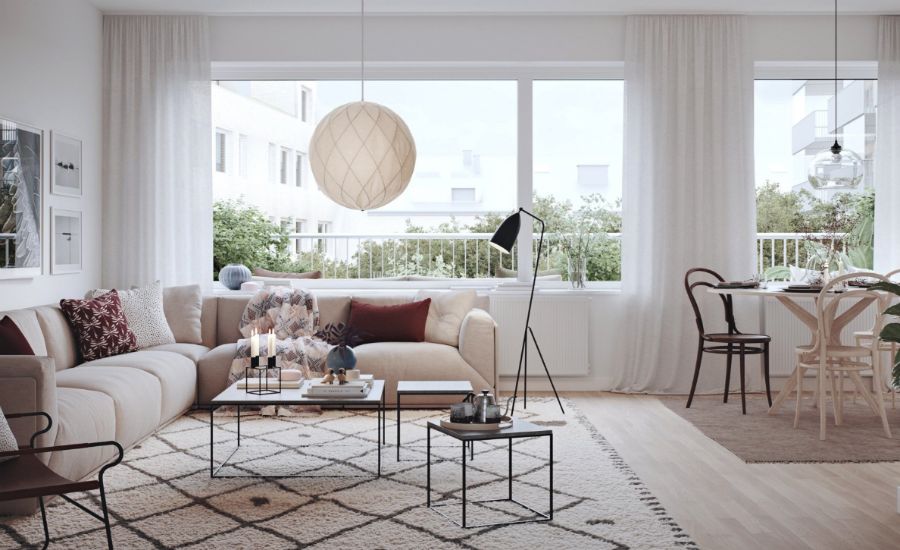 Modernt, ljust vardagsrum med stora fönster, beige soffa, soffbord med inredningsdetaljer och matplats med trästolar i bakgrunden