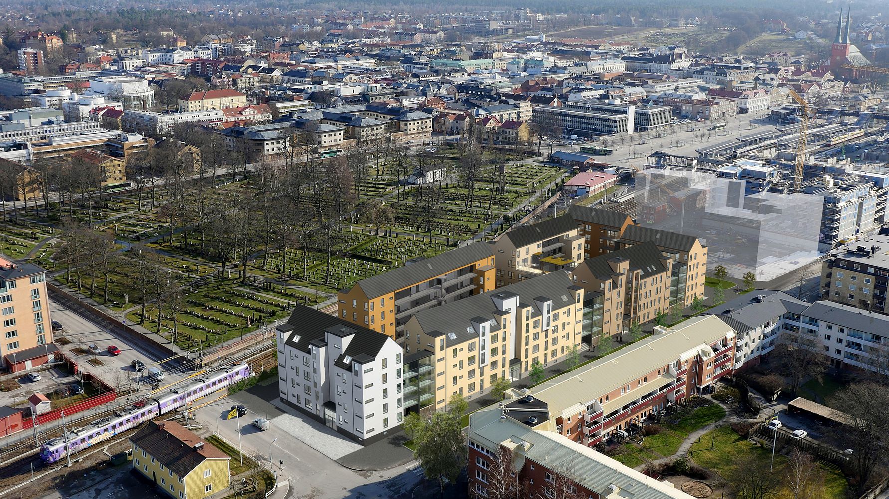Flygfoto över ett stadsområde med flerbostadshus, gröna parker, järnvägsspår och omgivande byggnader
