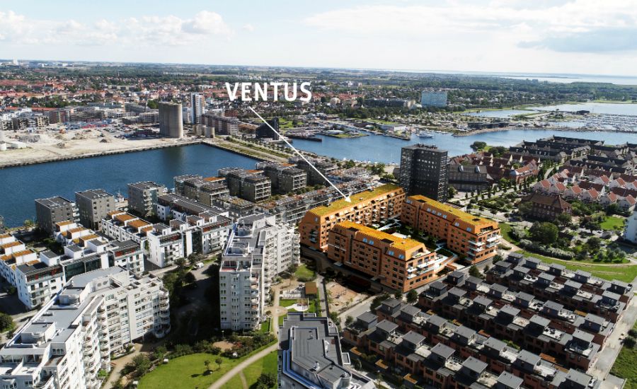 Flygfoto över ett bostadsområde vid vattnet med flera moderna byggnader, markerad text "Ventus" som pekar på en specifik byggnad