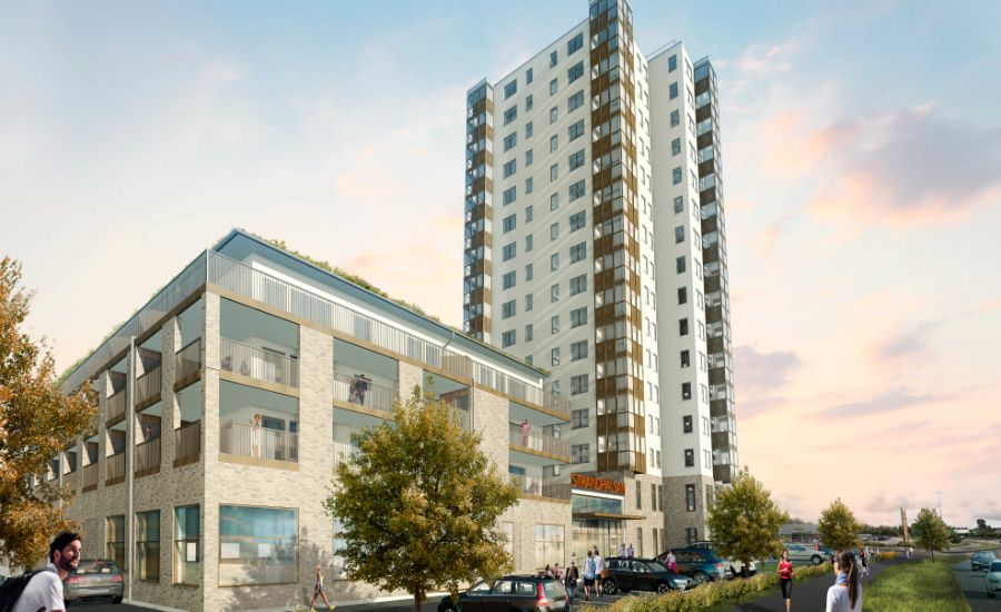 Flerbostadshus med modern arkitektur, inklusive en låg byggnad med balkonger och en hög tornbyggnad, omgiven av grönska och personer som promenerar