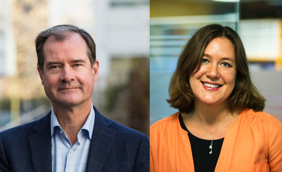 Två personer inomhus; en man i kostym och skjorta på vänster sida och en kvinna i orange tröja och halsband på höger sida