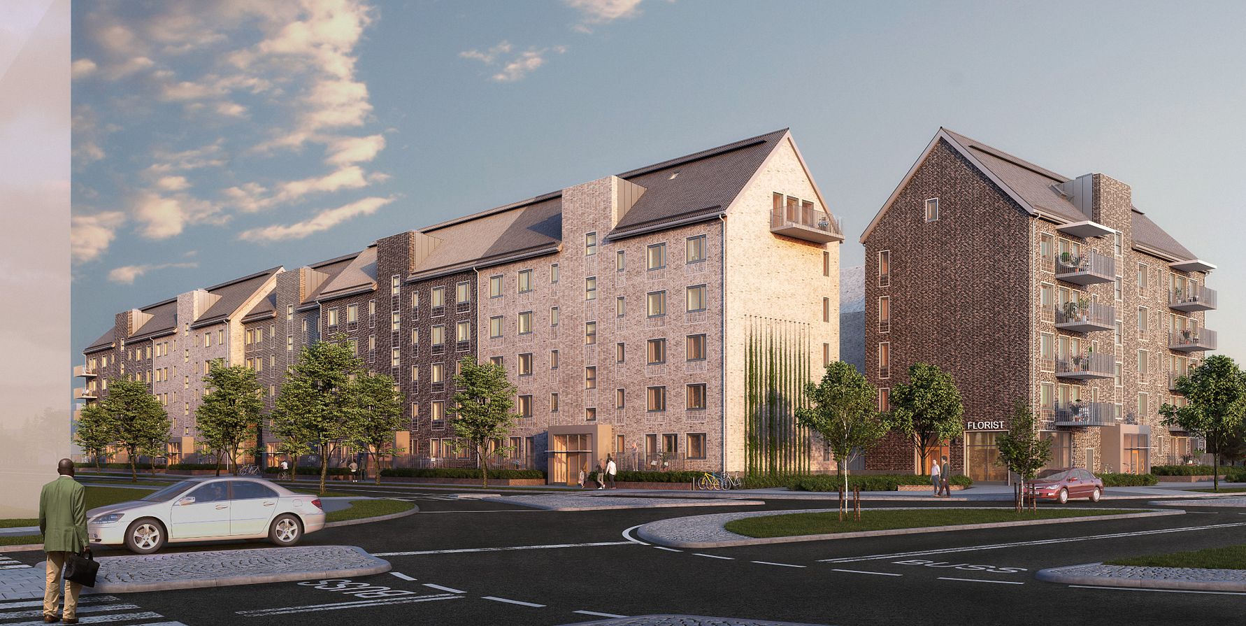 Flerbostadshus med modern arkitektur, omgivna av träd och en vägkorsning