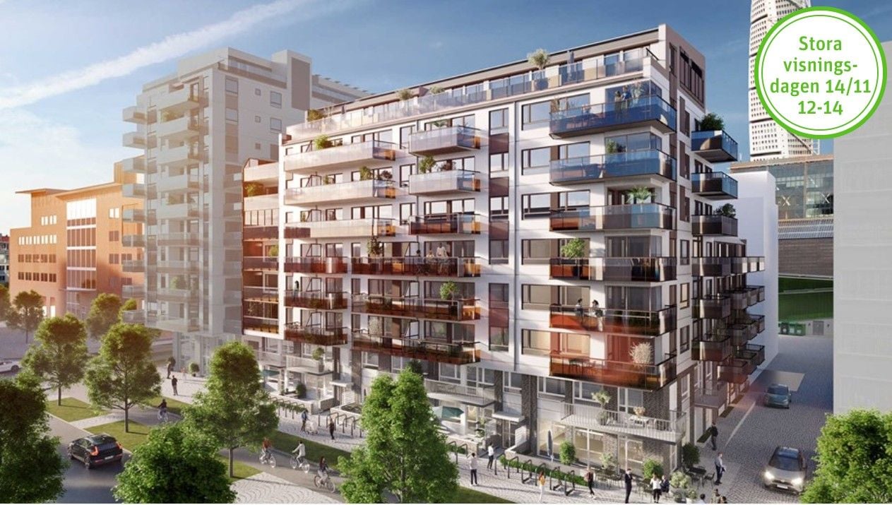 Modern lägenhetsbyggnad med flera våningar, balkonger och glasfasad, omgiven av grönska och mindre byggnader i stadsmiljö