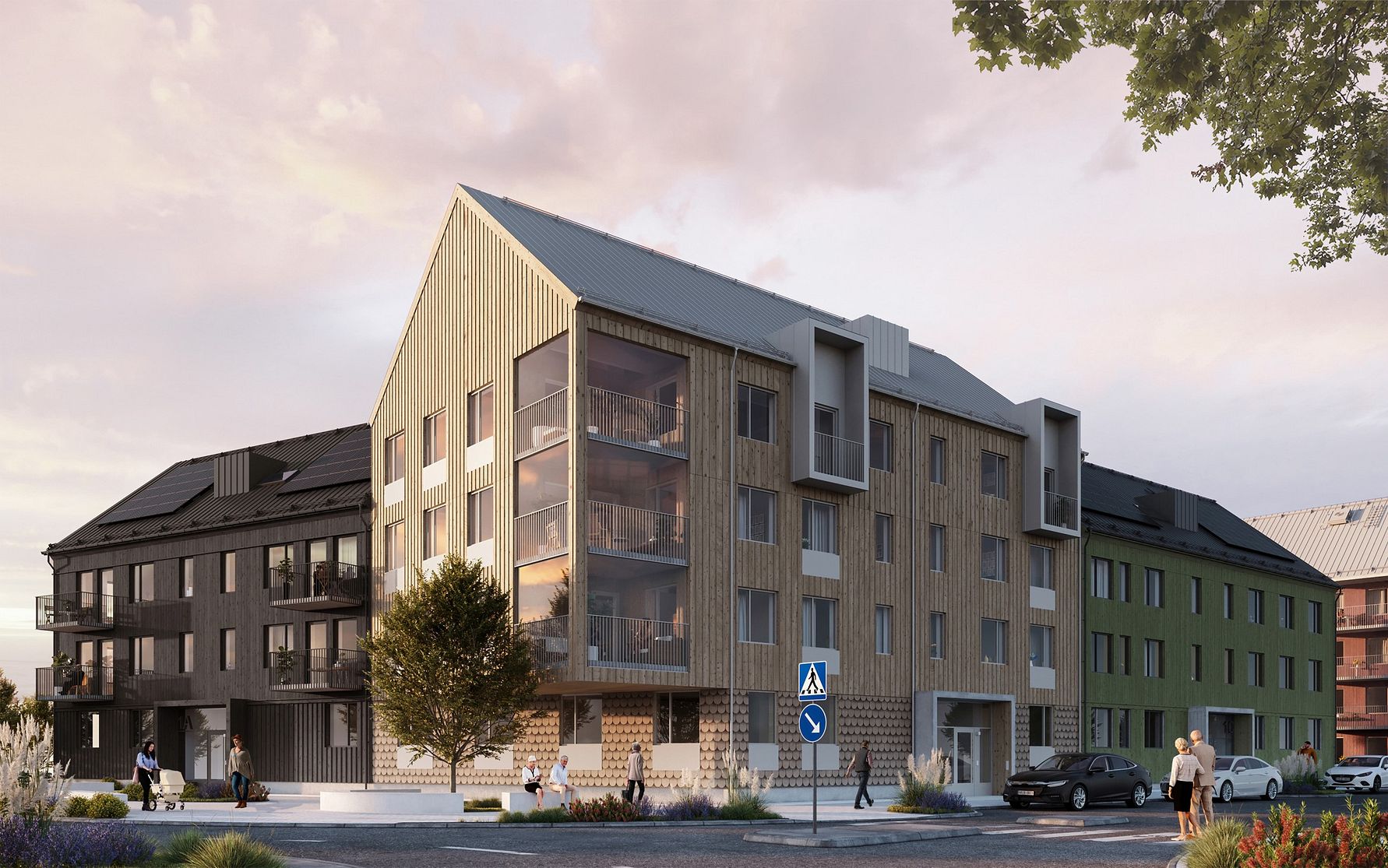 Nybyggnad med flera våningar, moderna fasader i trä och glas, omgiven av trottoar, parkeringsplats och grönska under en ljus himmel