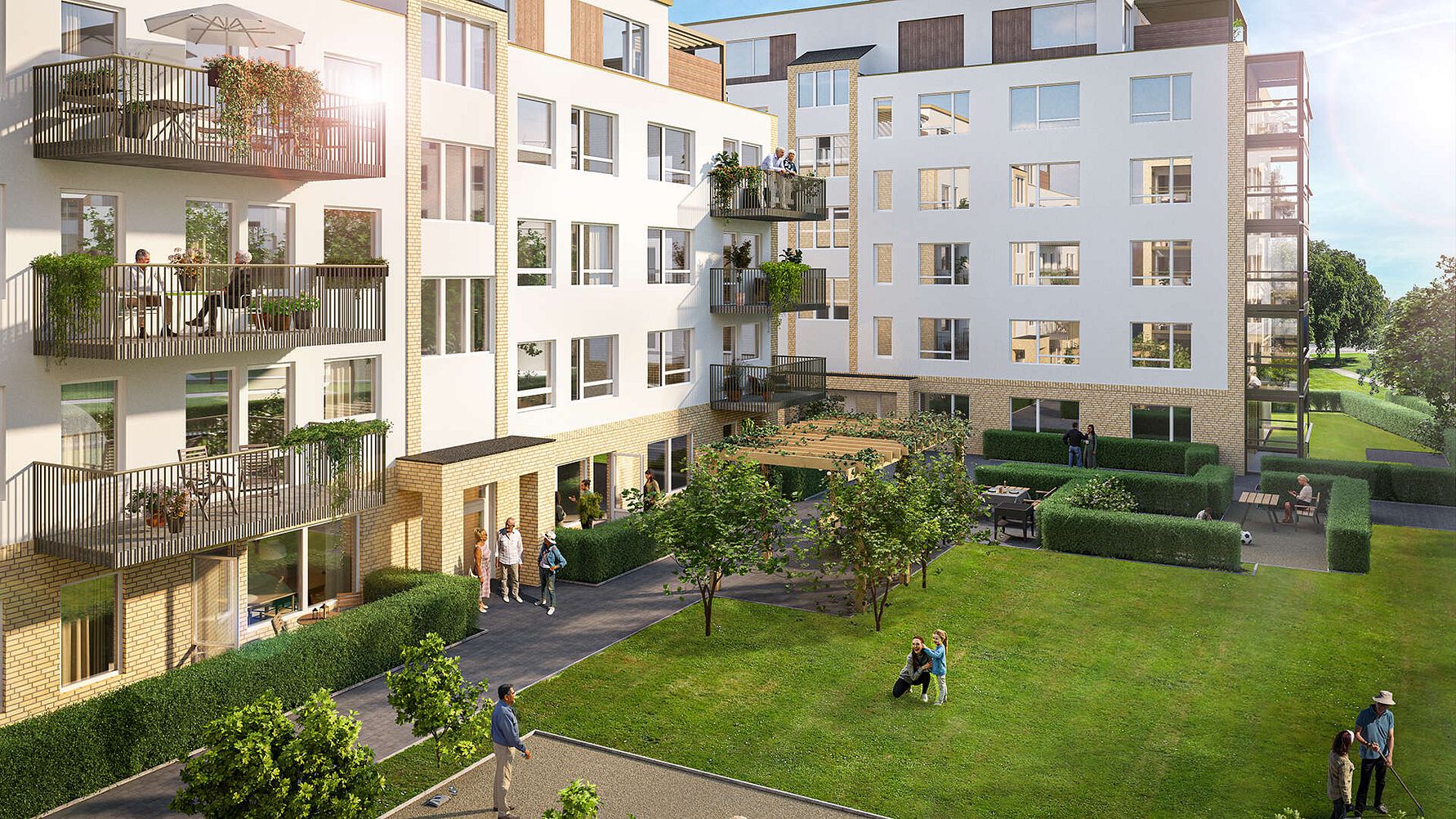 Modernt bostadsområde med vita byggnader, balkonger och en grön innergård med träd och gräsmatta