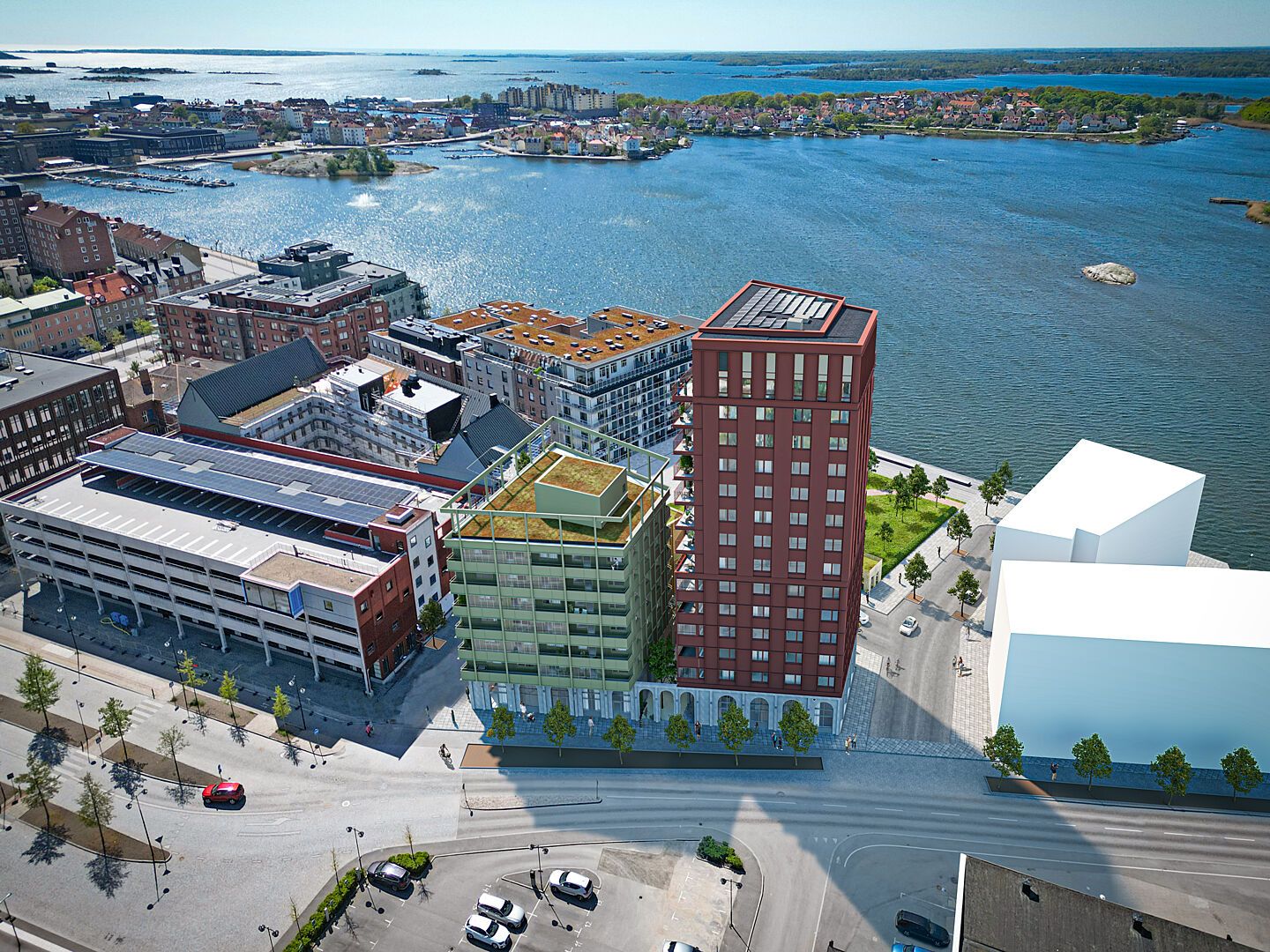 Flygvy över inflyttningsklara bostäder vid vattnet med flera moderna flerbostadshus och grön innergård