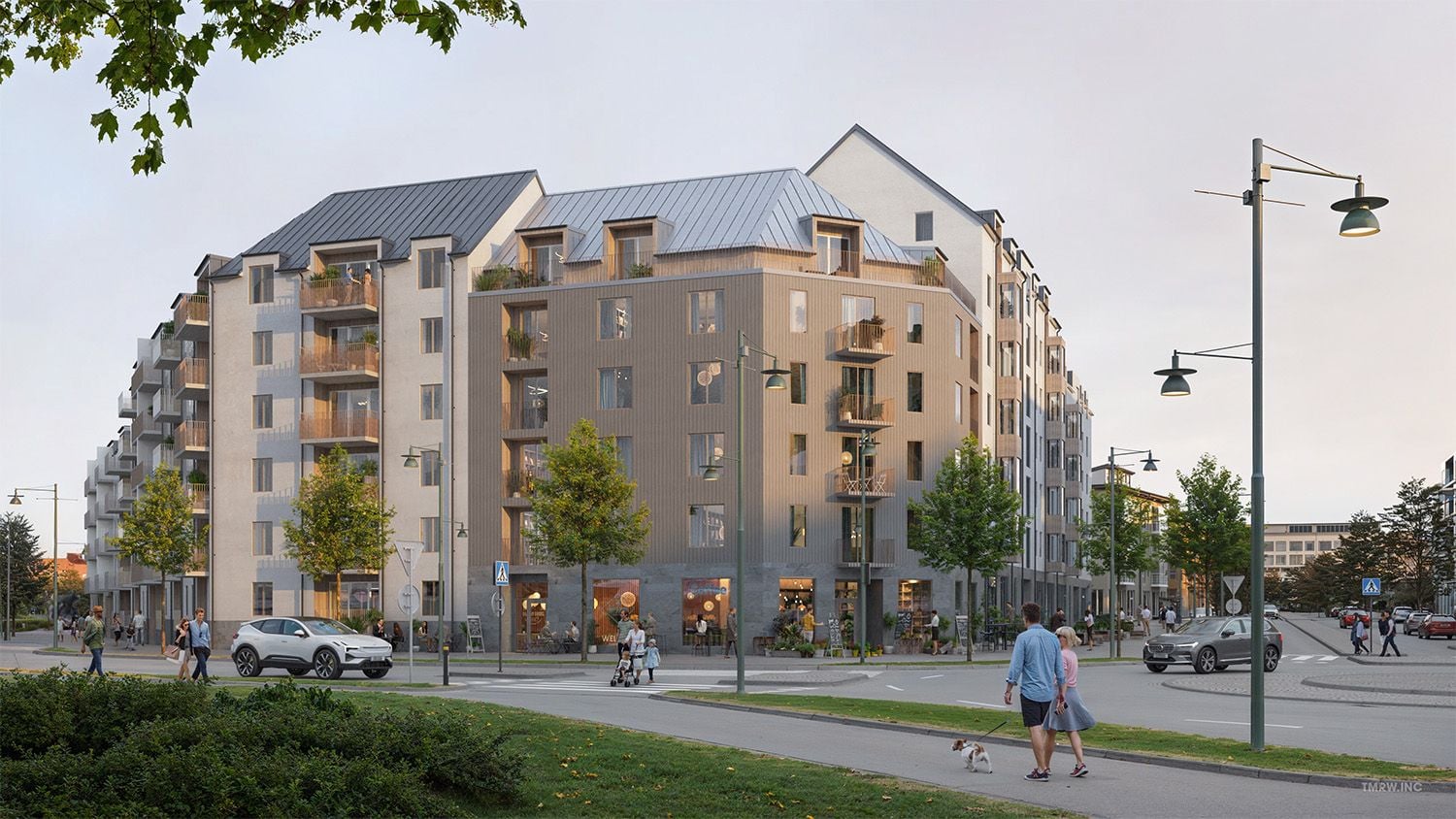 Nybyggd flerfamiljsfastighet med modern arkitektur, omgiven av gröna träd, trottoarer och gatlampor. Människor promenerar och en bil är parkerad nära byggnaden
