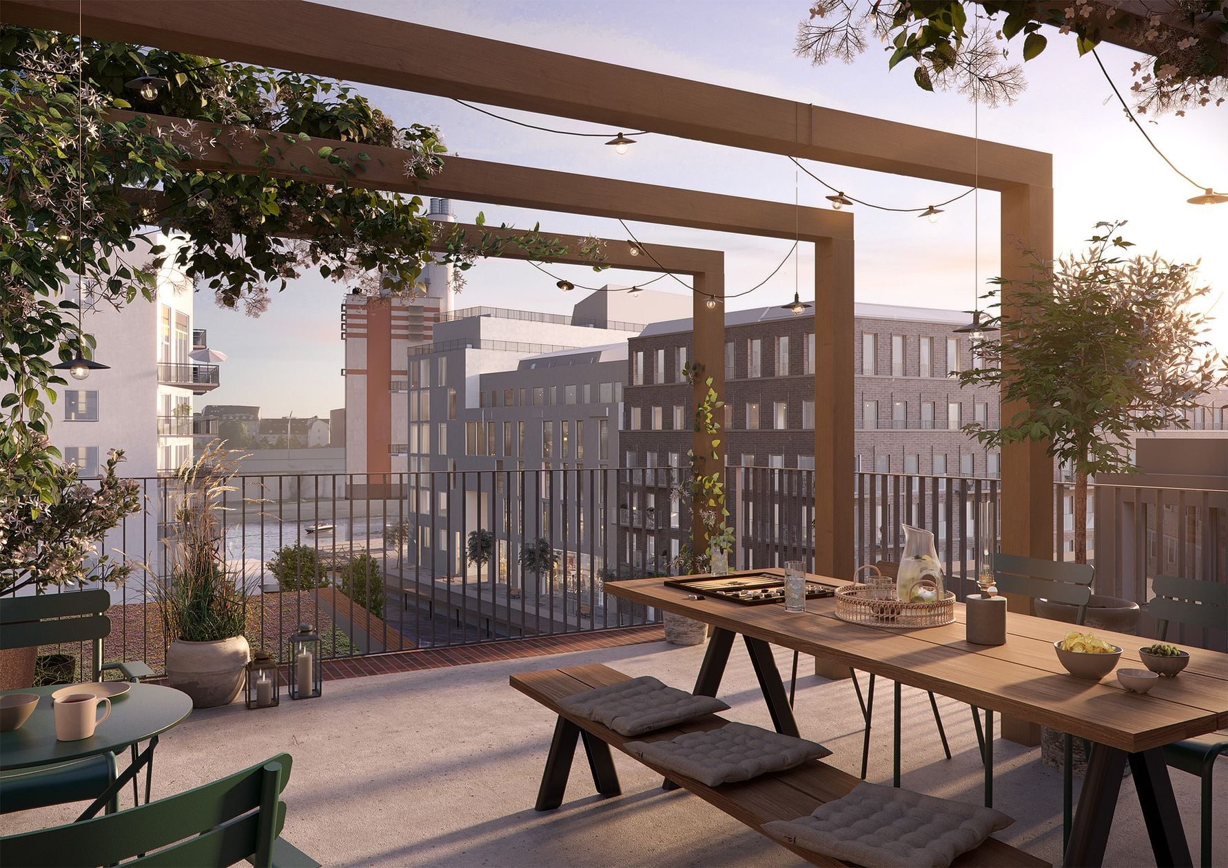 Utsikt från en terrass med träbord och bänkar, omgiven av växter och modern stadsbebyggelse i bakgrunden