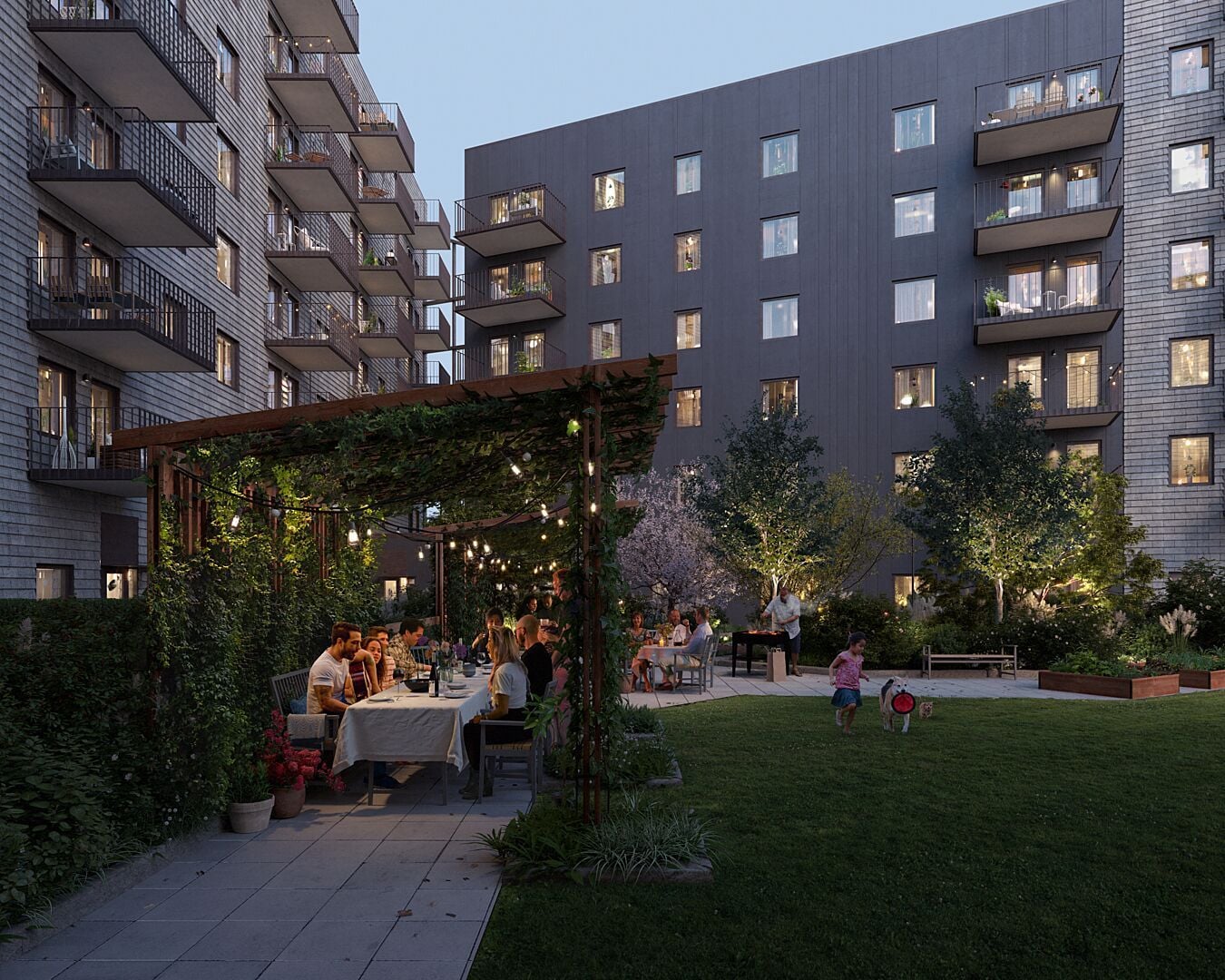 Bostadshus med flera våningar och balkonger, en grön innergård med människor som sitter vid ett bord och umgås, medan barn leker på gräsmattan