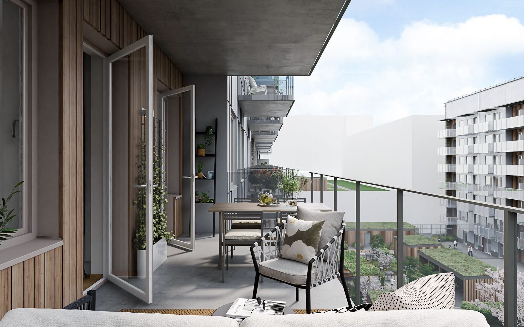 Balkong med utemöbler, växter och utsikt över en modern bostadsområde med grönområde i bakgrunden