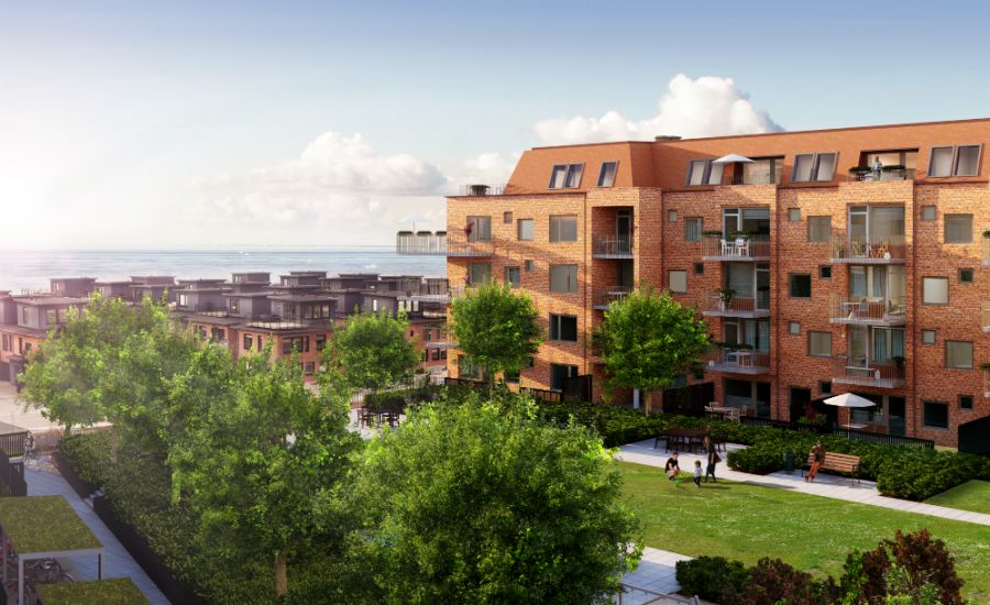 Flera flerfamiljshus i tegel med balkonger, grönskande träd och öppna gräsmattor i en modern bostadsområde