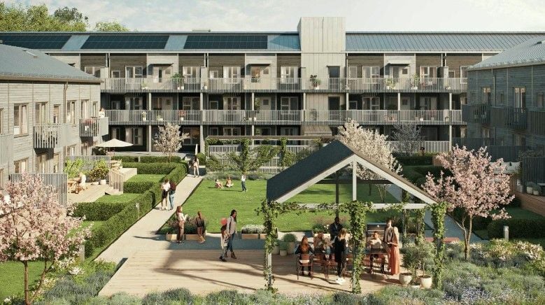 Modernt flerfamiljshus med träfasad och solpaneler, omgiven av en grön innergård med planteringar, träd, sittplatser och människor som umgås