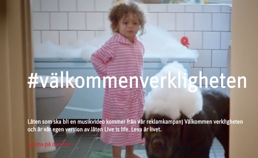 Ett barn i en randig rosa nattlinne står i ett badrum med ett badkar i bakgrunden och en hund med skum på huvudet bredvid
