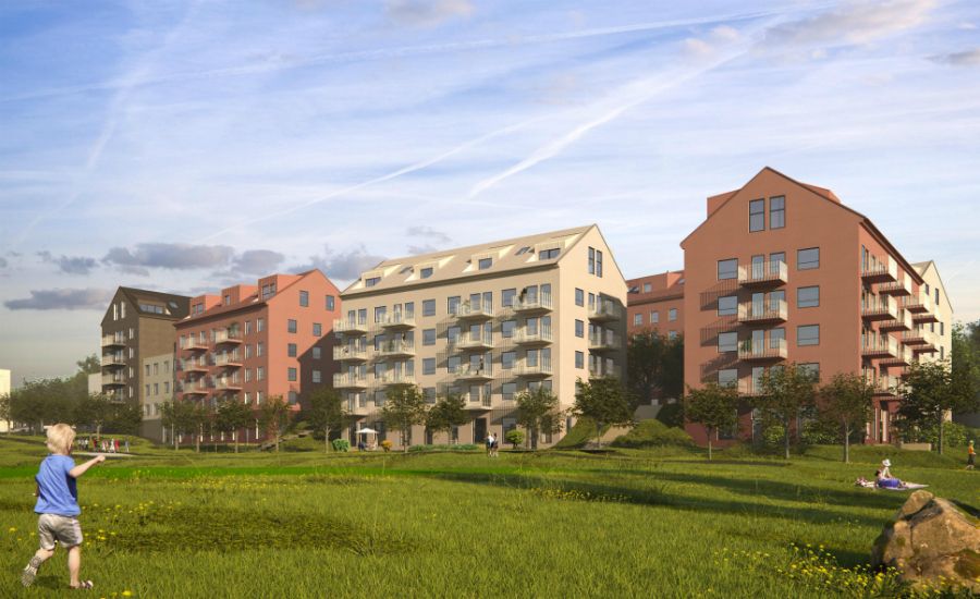 Flera flerfamiljshus i modern stil omgivna av grönområden, med en gräsmatta och lekande barn i förgrunden under en blå himmel