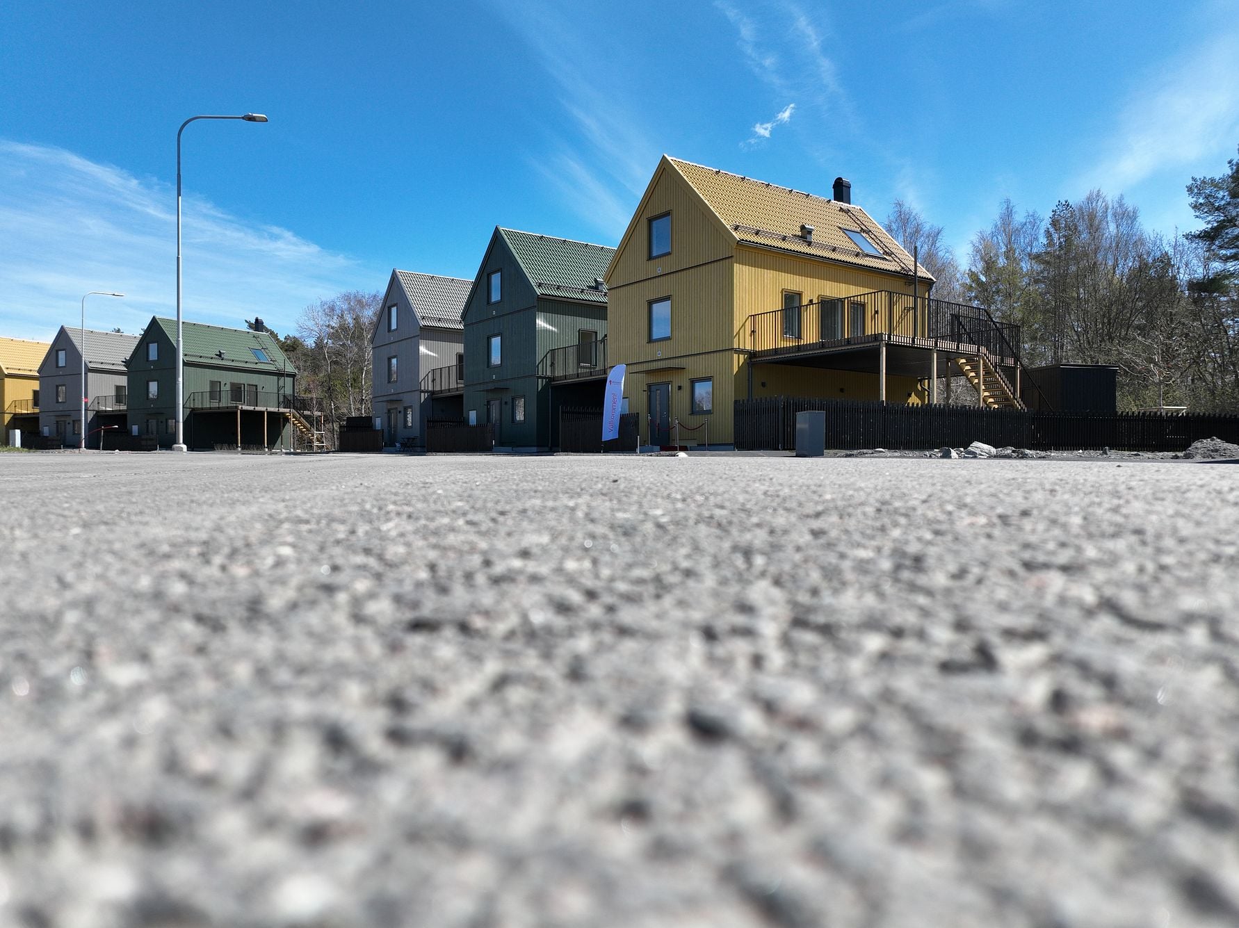Flera färgglada flerbostadshus vid en gata under en blå himmel