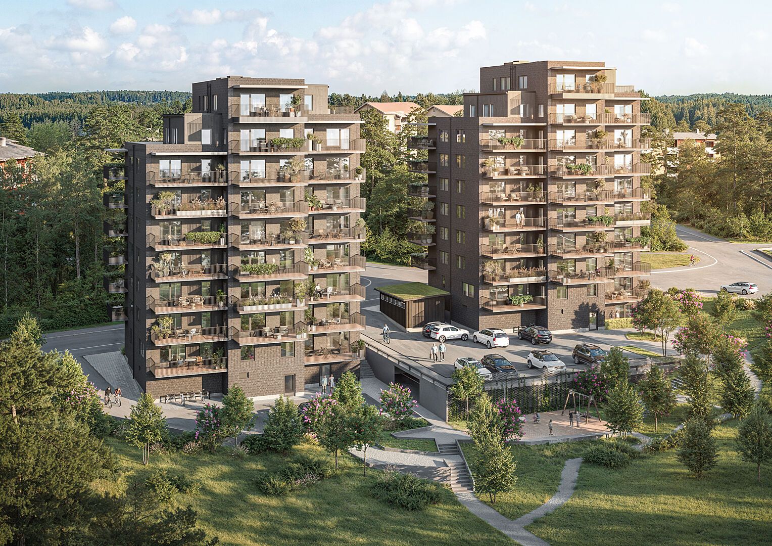 Flera moderna lägenhetsbyggnader med balkonger, omgivna av grönska och parkeringsplatser på en solig dag