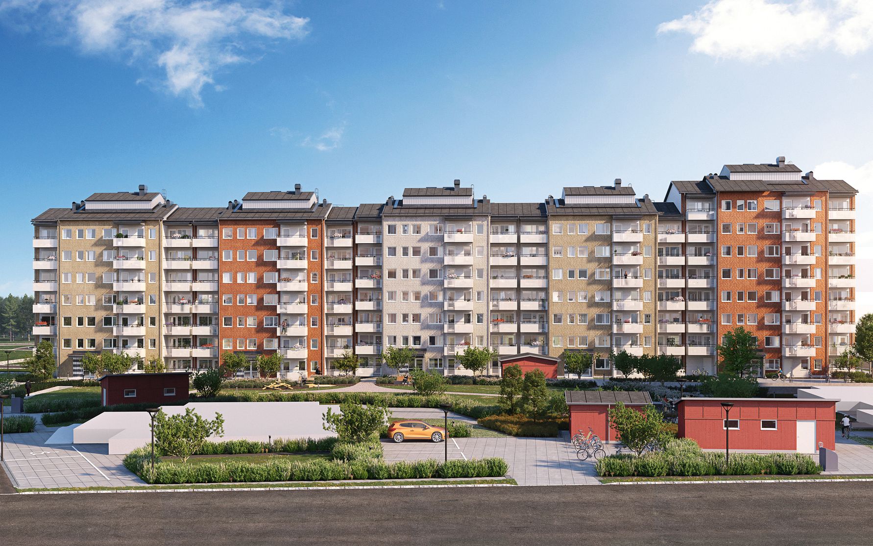 Flerfamiljshus med sex våningar i olika färger, omgivna av gröna områden, parkeringsplats och några små byggnader under en klar blå himmel