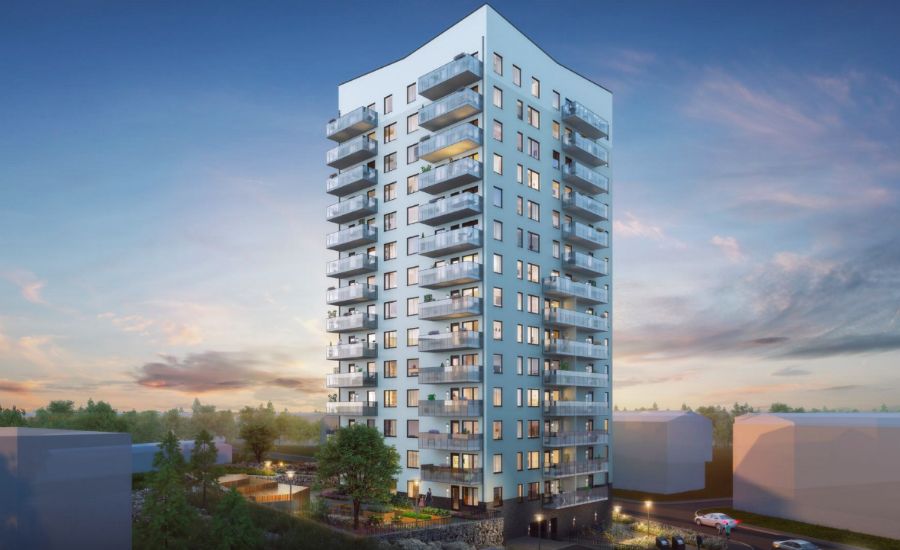 Höghus i modern arkitektur med flera balkonger, omgiven av grönska och byggnader, mot en bakgrund av solnedgång