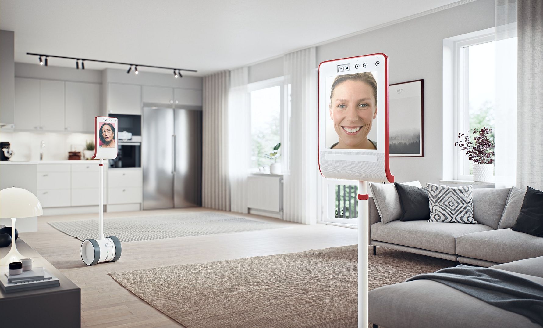 En modern inredning i ett ljust vardagsrum och kök med två robotar på hjul med skärmar placerade på golvet
