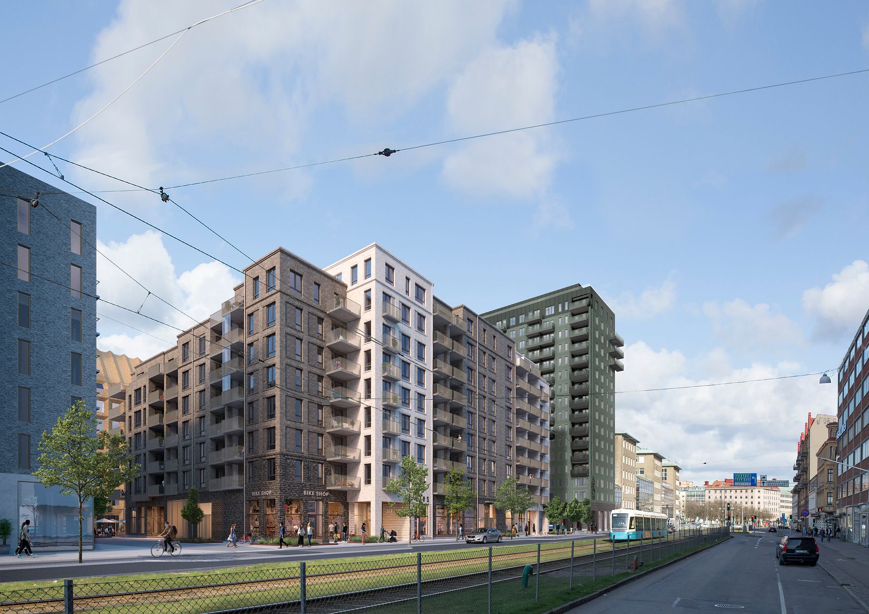 Flera moderna flerfamiljshus längs en stadsgata med spårvagn och cyklister, omgivna av träd och en klar blå himmel