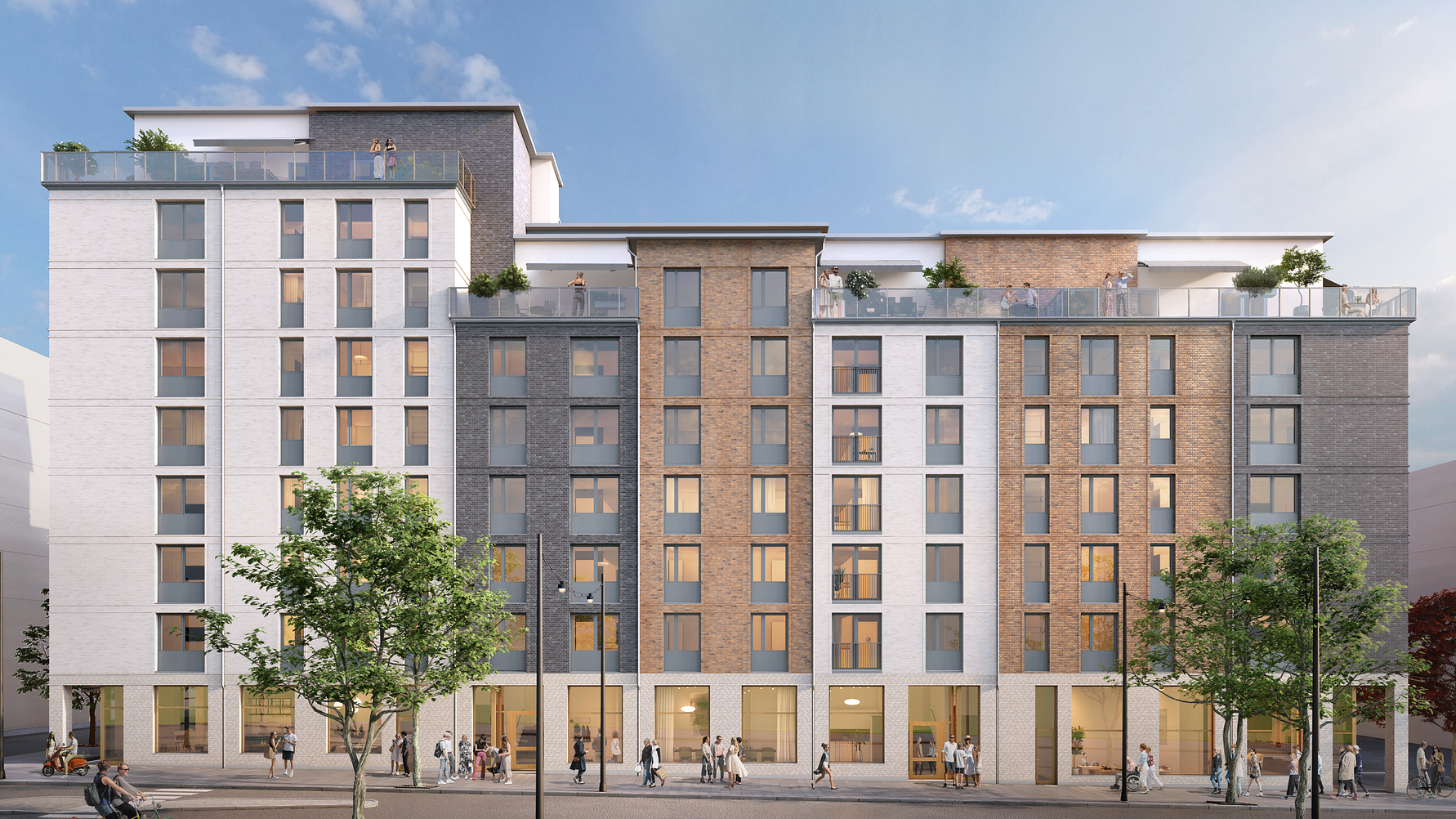 Flerbostadshus i modern arkitektur med fasader i vitt, grått och brunt, omgivna av träd och fotgängare på gatan