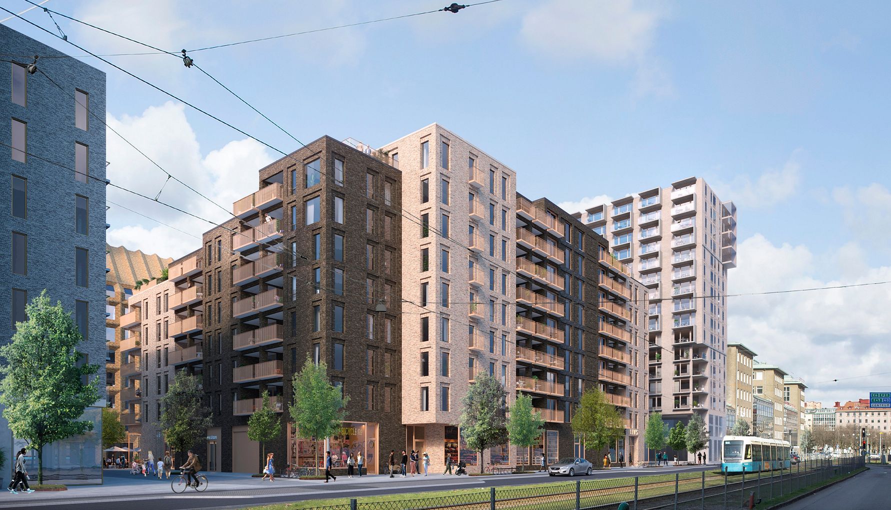 Flera moderna flerfamiljshus längs en gata med spårvagn, träd och gångväg i en stadsmiljö