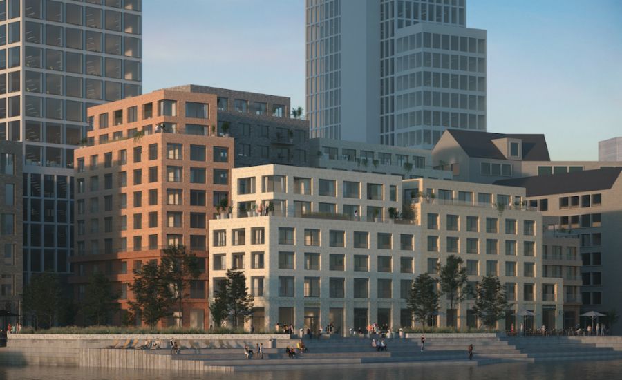 Flera moderna bostadshus vid vattnet, omgivna av träd och en kaj med människor